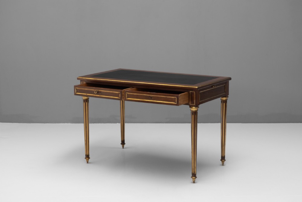 A French Louis XVI style mahogany bureau plat featuring a dark leather writing insert, gilt-bronze trim, frieze drawers, and fluted tapered legs. View III