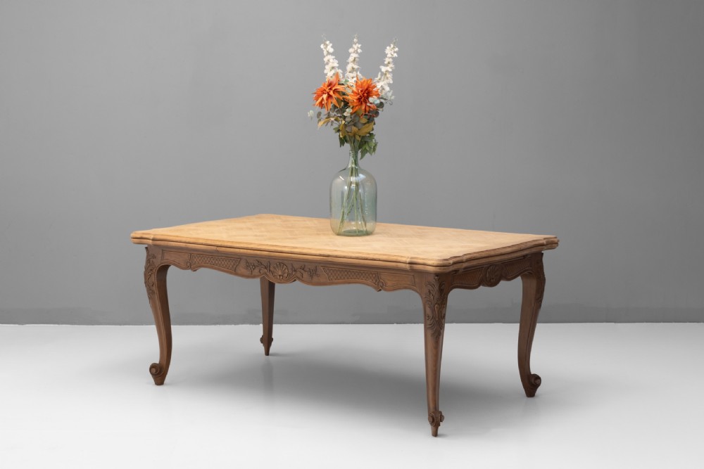 An extendable French Provincial oak dining table with a parquet top, carved shell apron, and cabriole legs ending in scroll feet. View II