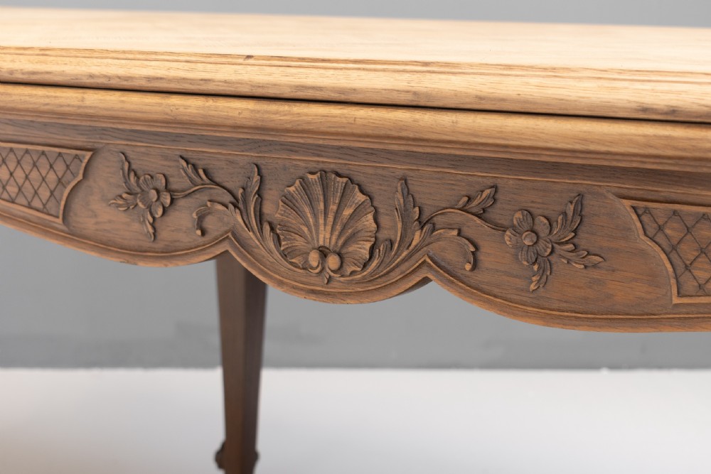 An extendable French Provincial oak dining table with a parquet top, carved shell apron, and cabriole legs ending in scroll feet. View IX