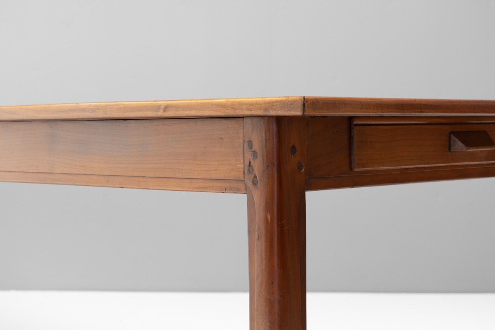 A long rectangular antique cherry wood farm table featuring straight legs and a smooth polished finish. View VI