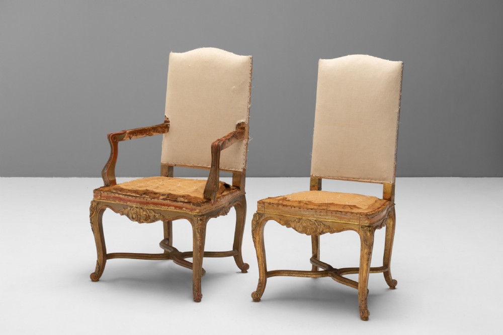 A set of six French gilded dining chairs featuring carved wooden frames, high backrests, and curved cabriole legs. View II