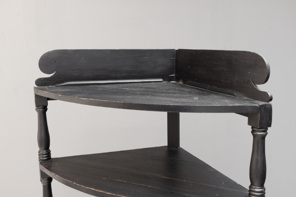 A tall 19th-century ebonised wooden corner shelf unit featuring six tiered triangular shelves and turned spindle supports. View IV