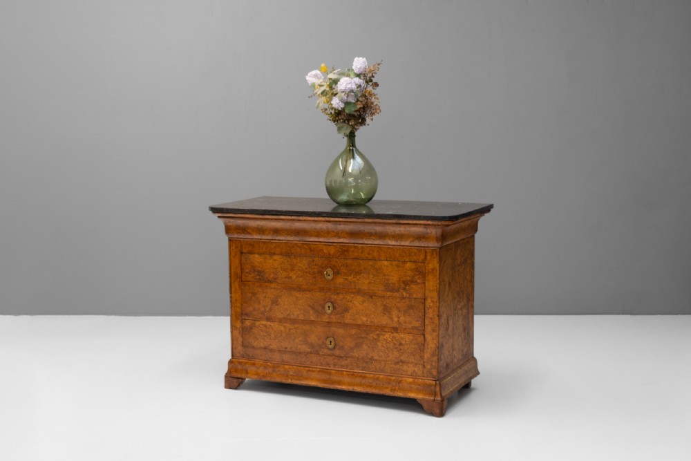 A 19th-century elm commode chest of drawers featuring a dark marble top, three full-width drawers with oval brass escutcheons, and a prominent figured wood grain. View II