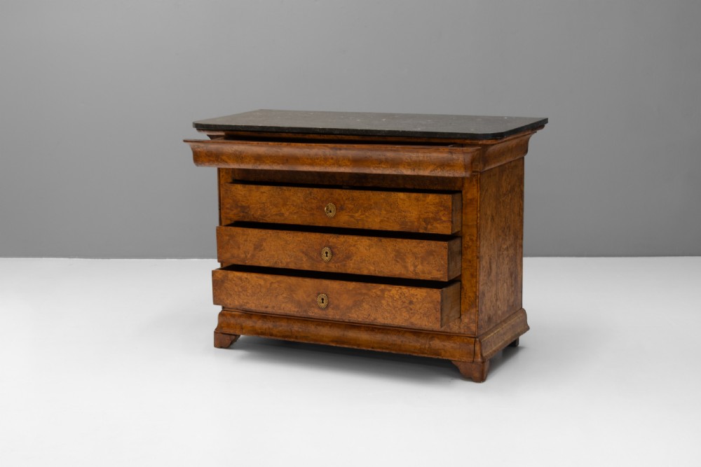 A 19th-century elm commode chest of drawers featuring a dark marble top, three full-width drawers with oval brass escutcheons, and a prominent figured wood grain. View III