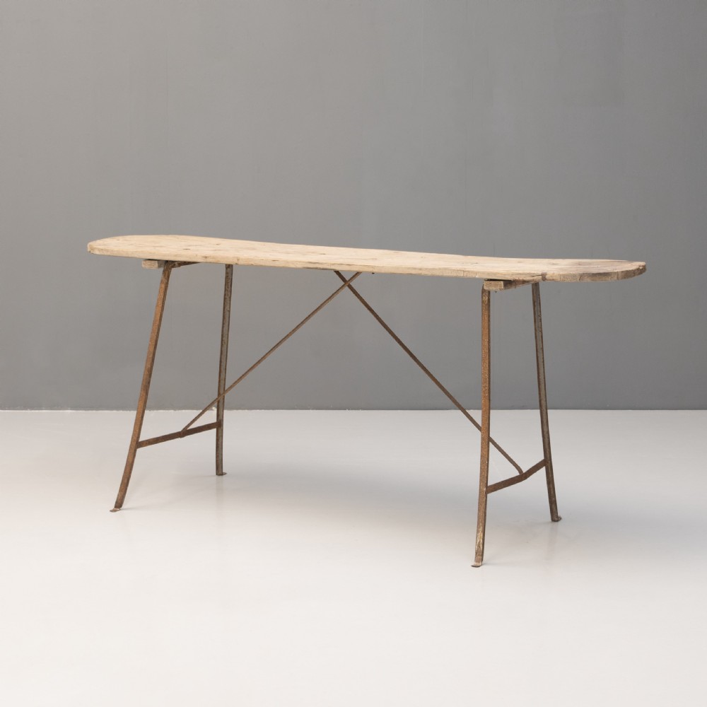 A long narrow rustic table featuring a natural pale wood top with rounded ends supported by slender brown metal legs with diagonal cross-bracing. View II