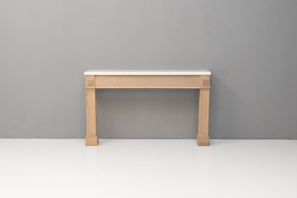 A light oak console table featuring rectangular pilaster legs on plinths and a thick rectangular white marble top set against a neutral grey wall. View II