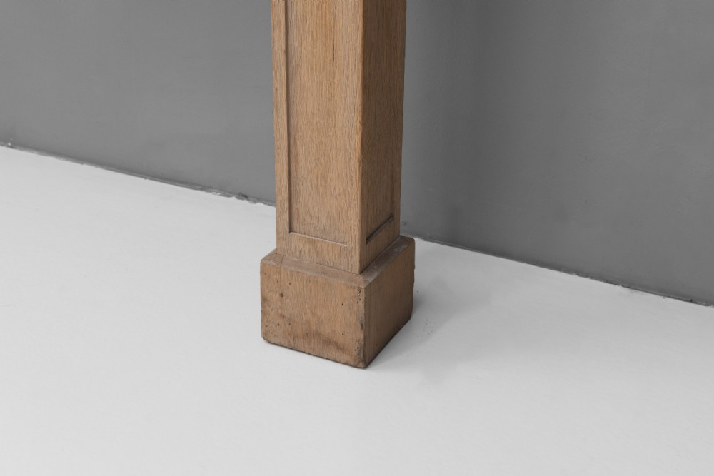 A light oak console table featuring rectangular pilaster legs on plinths and a thick rectangular white marble top set against a neutral grey wall. View VI