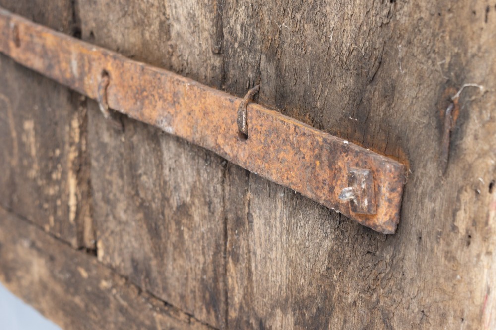 A tall weathered antique oak plank door featuring vertical wooden boards joined with visible iron studs and a natural aged patina. View X