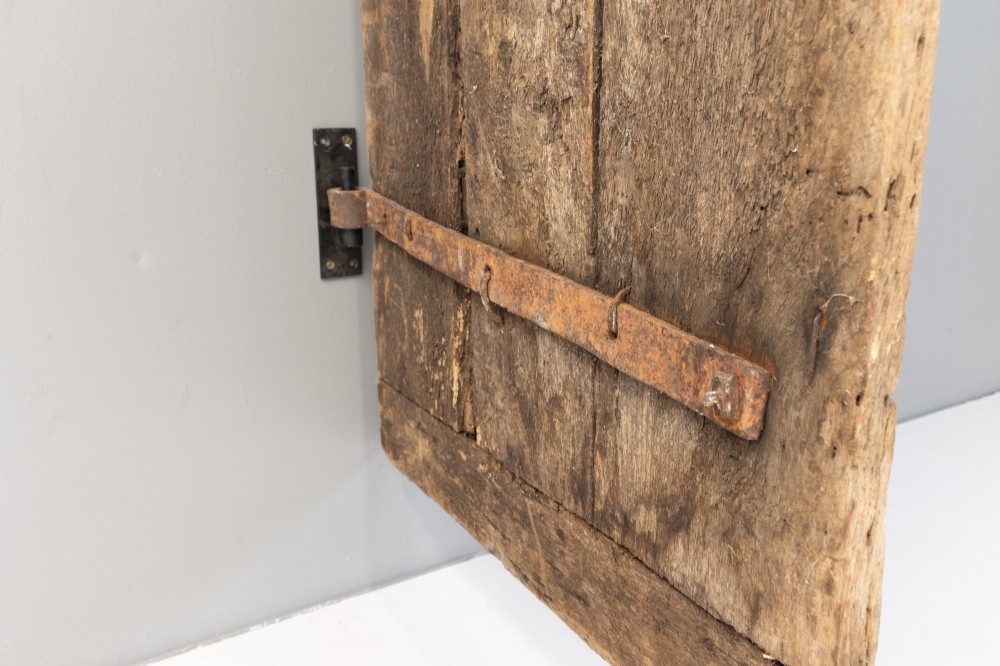 A tall weathered antique oak plank door featuring vertical wooden boards joined with visible iron studs and a natural aged patina. View XI