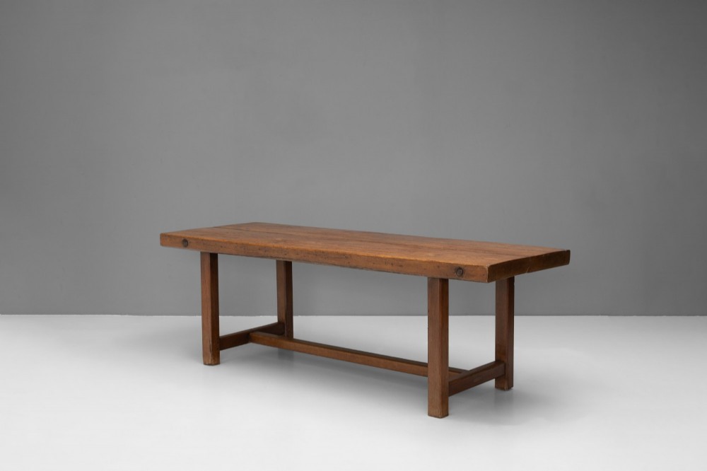 A long rustic wooden farmhouse dining table with a thick plank top, square legs, and an H-stretcher base. View II