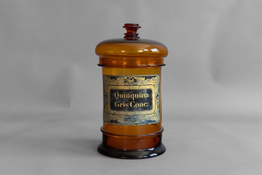 A pair of cylindrical amber glass apothecary jars with glass stoppers and original gilded French labels. View III