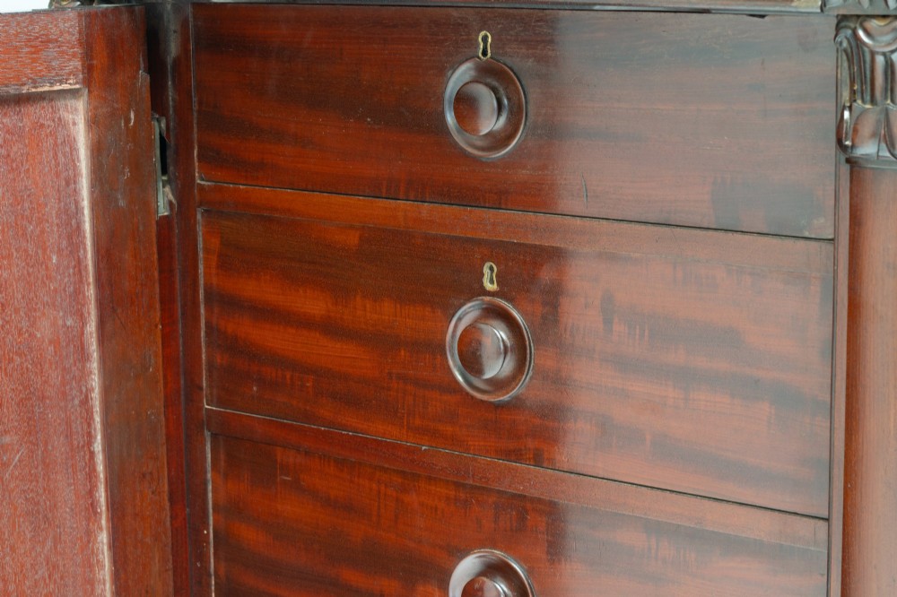 A large mahogany two-tier bookcase featuring twin upper glazed doors with arched glazing bars and a lower cupboard section with carved accents. View VII