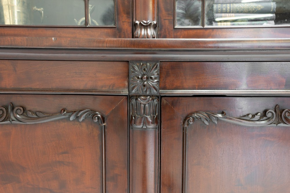 A large mahogany two-tier bookcase featuring twin upper glazed doors with arched glazing bars and a lower cupboard section with carved accents. View VIII