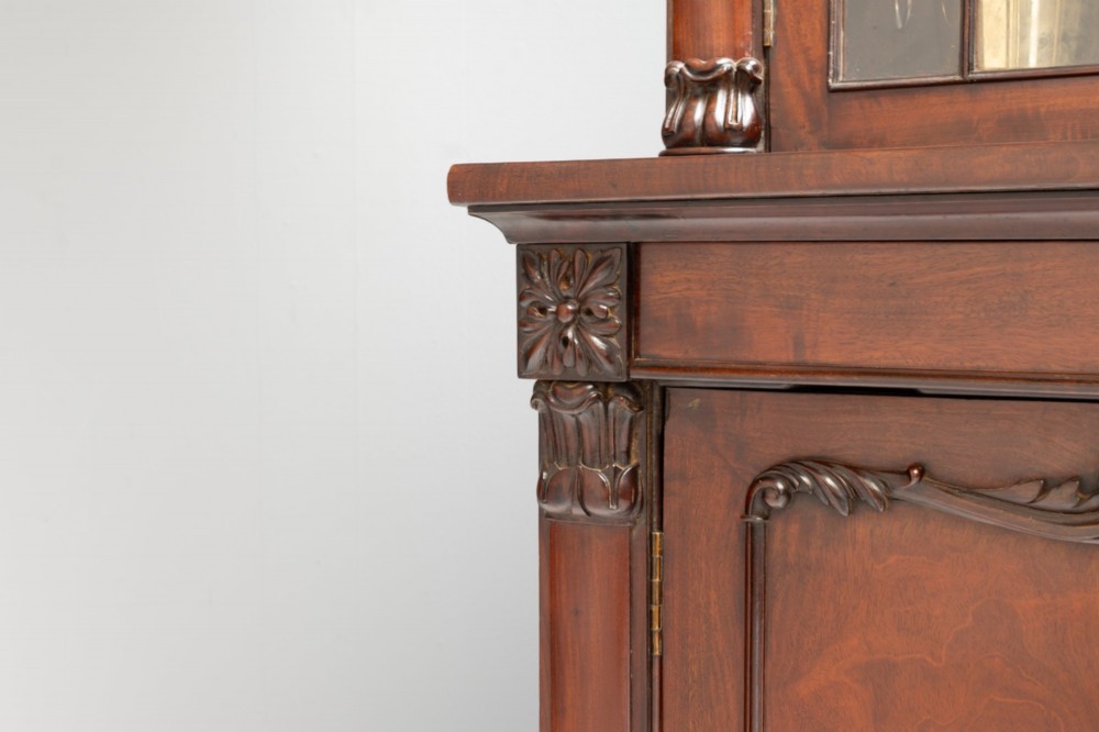 A large mahogany two-tier bookcase featuring twin upper glazed doors with arched glazing bars and a lower cupboard section with carved accents. View IX