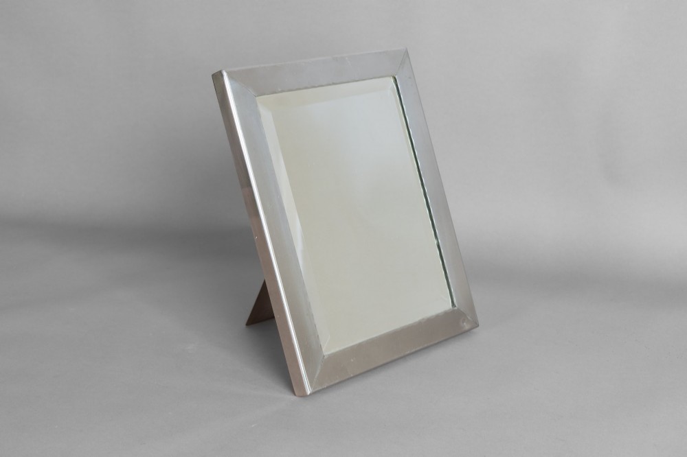 A rectangular silver-plated vanity mirror featuring a bevelled glass edge and an easel back support.