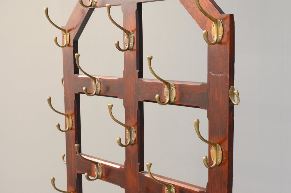 A tall Victorian mahogany hallstand featuring an architectural pediment cresting, multiple brass coat hooks, and a lower stick stand with an integrated drip tray. View V