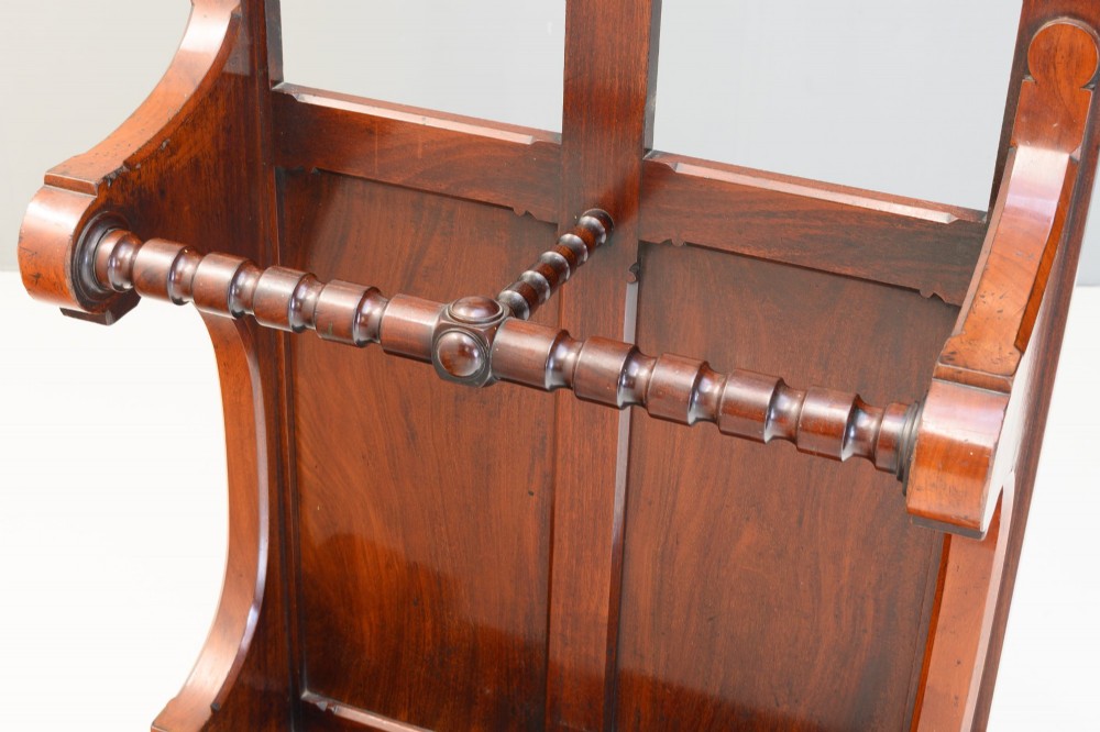 A tall Victorian mahogany hallstand featuring an architectural pediment cresting, multiple brass coat hooks, and a lower stick stand with an integrated drip tray. View VI