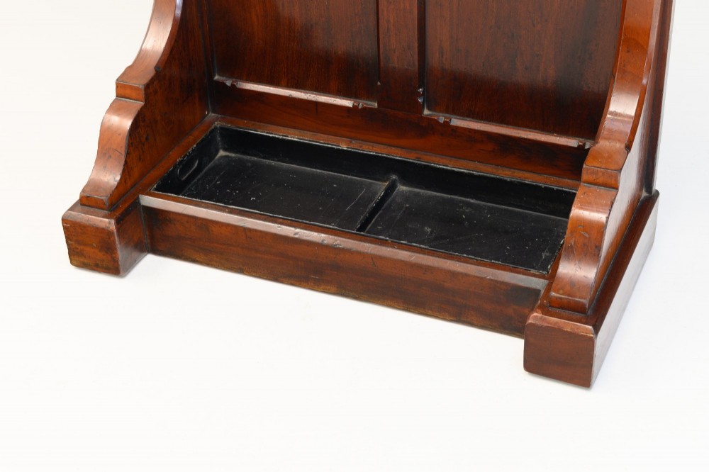 A tall Victorian mahogany hallstand featuring an architectural pediment cresting, multiple brass coat hooks, and a lower stick stand with an integrated drip tray. View VII