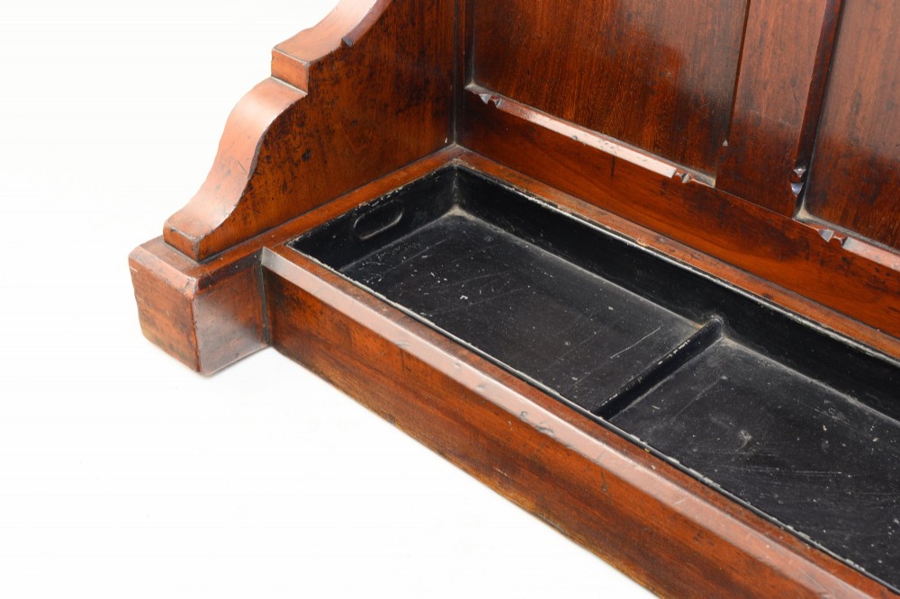 A tall Victorian mahogany hallstand featuring an architectural pediment cresting, multiple brass coat hooks, and a lower stick stand with an integrated drip tray. View VIII