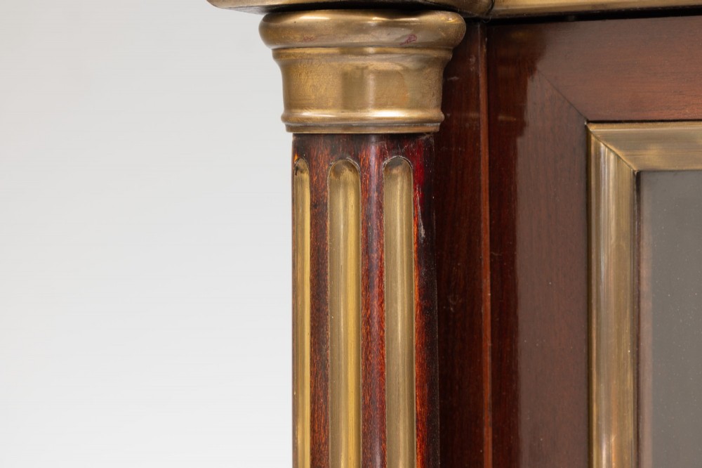A dark mahogany two-door glazed bookcase featuring brass line inlay, fluted brass-capped columns, and glass doors over solid wood panels. View VIII