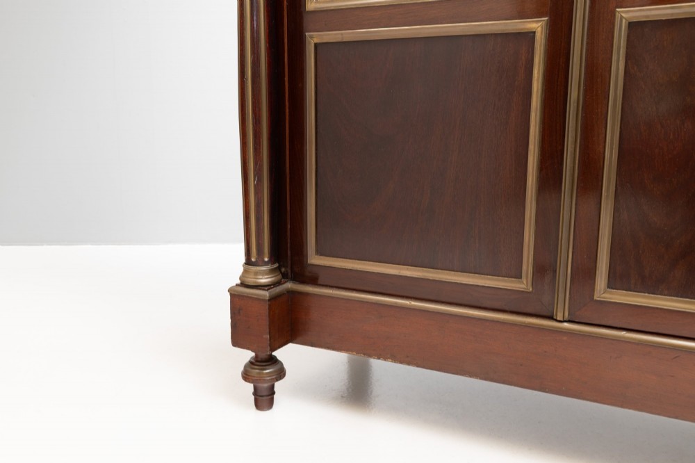 A dark mahogany two-door glazed bookcase featuring brass line inlay, fluted brass-capped columns, and glass doors over solid wood panels. View IX
