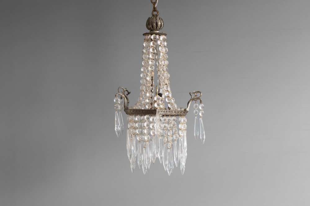 An antique French style crystal chandelier featuring tiered glass prisms, beaded crystal strands, and a decorative aged brass frame. View II