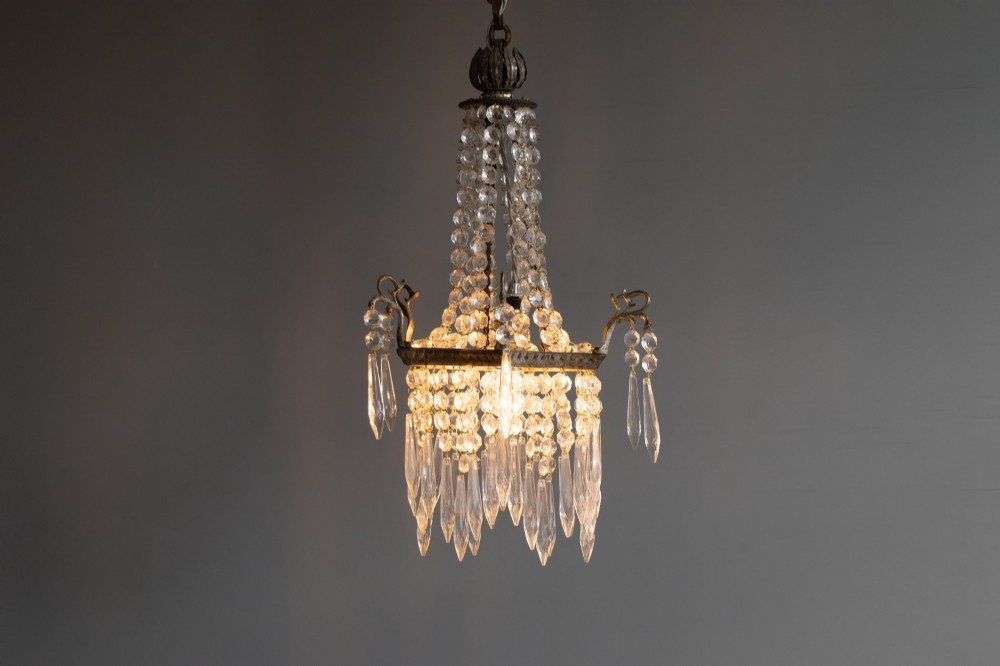 An antique French style crystal chandelier featuring tiered glass prisms, beaded crystal strands, and a decorative aged brass frame. View III