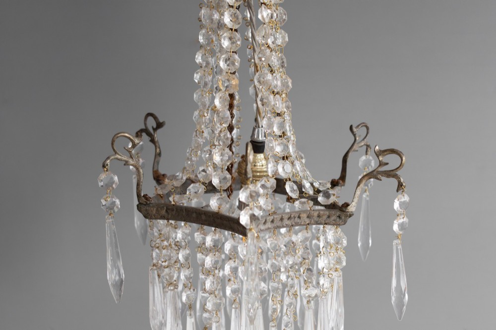 An antique French style crystal chandelier featuring tiered glass prisms, beaded crystal strands, and a decorative aged brass frame. View V