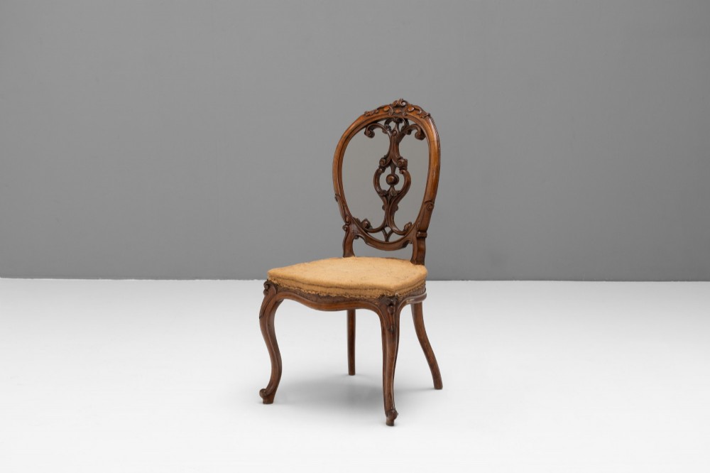 A pair of antique Victorian Rococo Revival carved timber side chairs with balloon backs, open scrollwork splats, cabriole legs, and neutral upholstery. View III