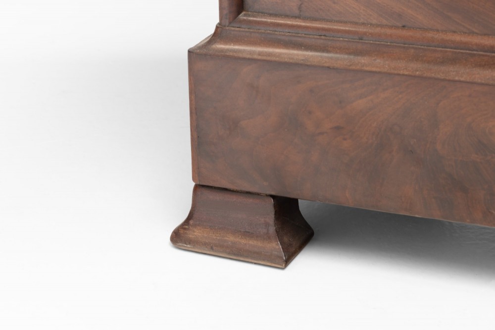 A nineteenth-century French mahogany commode featuring three main drawers, a grey marble top, and brass keyhole escutcheons. View VI