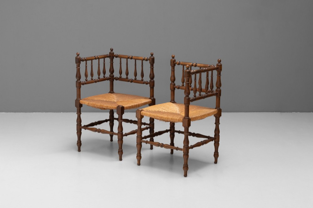 A pair of matching wooden corner chairs featuring turned bobbin spindles, raised armrests, turned leg stretchers, and square hand-woven rush seats. View II