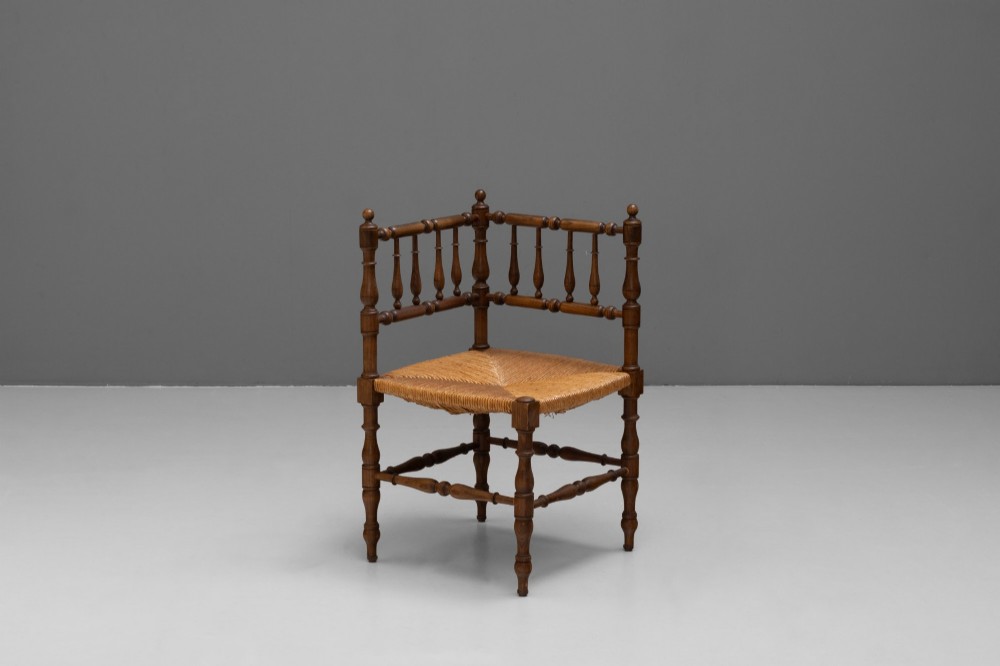 A pair of matching wooden corner chairs featuring turned bobbin spindles, raised armrests, turned leg stretchers, and square hand-woven rush seats. View III