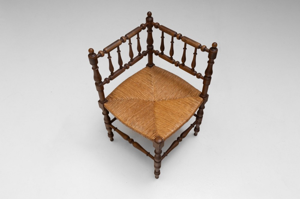 A pair of matching wooden corner chairs featuring turned bobbin spindles, raised armrests, turned leg stretchers, and square hand-woven rush seats. View IV