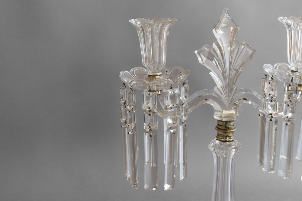 A pair of clear cut glass two-arm candelabras featuring hanging prism drops, fluted stems, and scalloped bases. View IV