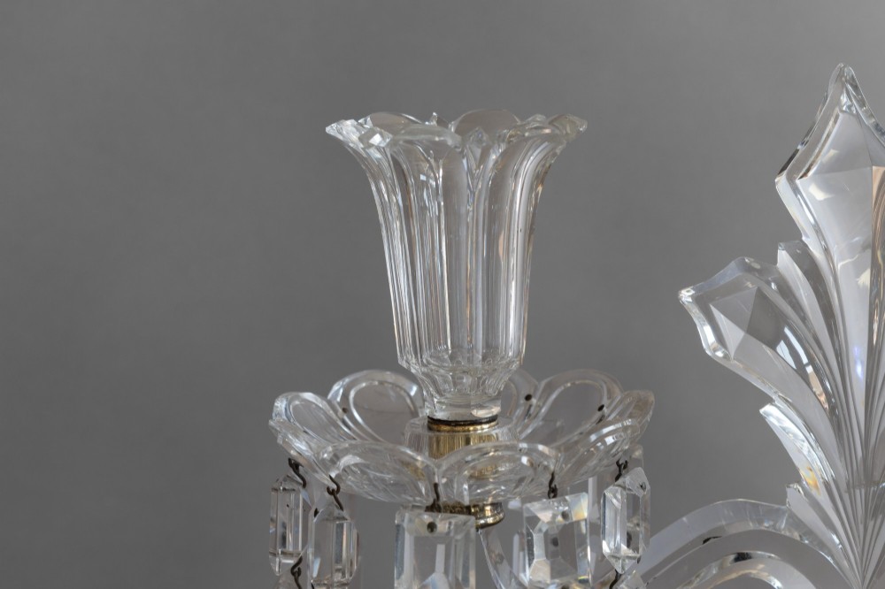 A pair of clear cut glass two-arm candelabras featuring hanging prism drops, fluted stems, and scalloped bases. View V
