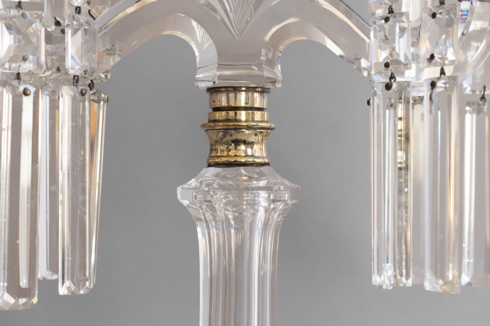 A pair of clear cut glass two-arm candelabras featuring hanging prism drops, fluted stems, and scalloped bases. View VII