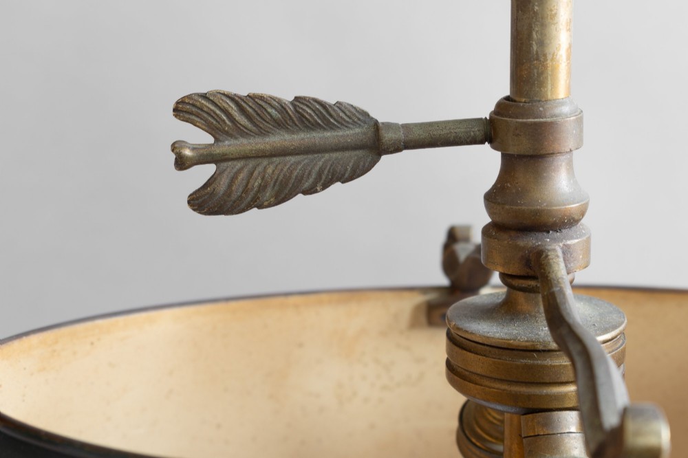 An antique French bouillotte lamp featuring a dark green metal tole shade, twin brass candle sconces, a central adjustment rod with a ring top, and a pierced dish base. View V