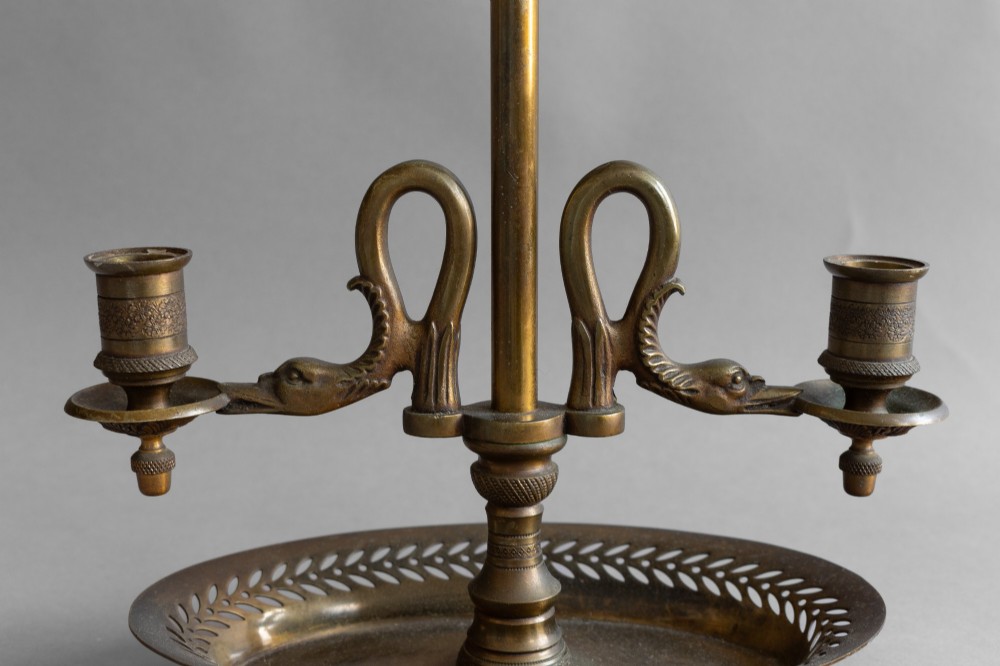 An antique French bouillotte lamp featuring a dark green metal tole shade, twin brass candle sconces, a central adjustment rod with a ring top, and a pierced dish base. View IX