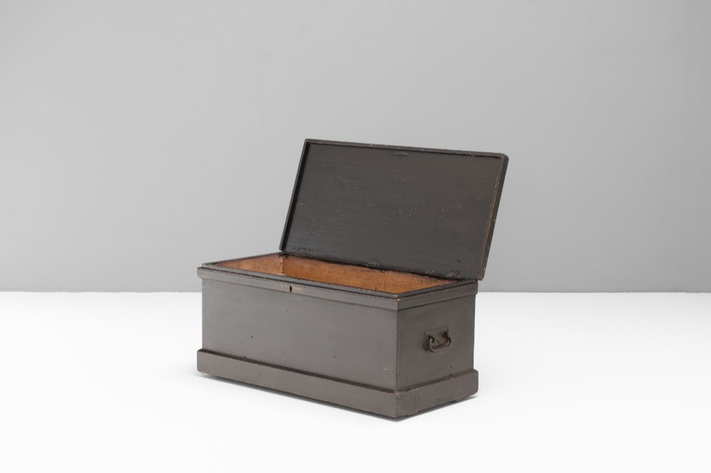 A dark painted rectangular pine storage trunk featuring an open hinged lid, natural pine interior, and iron side handles. View II