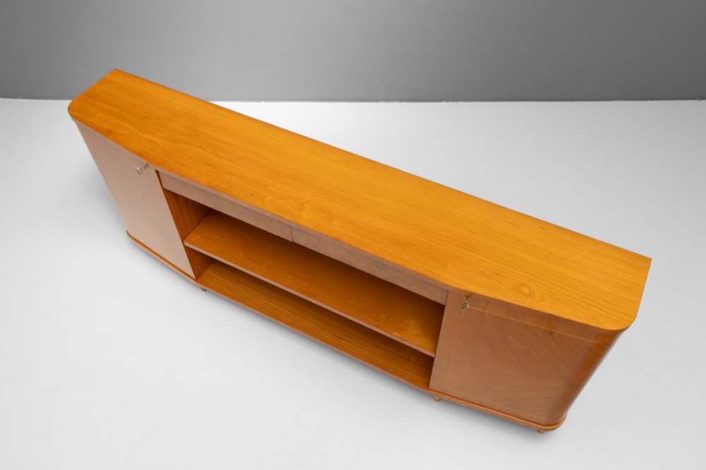 A Swedish Grace birch sideboard featuring chevron parquetry veneer doors, open central shelving, and tapered fluted feet. View V