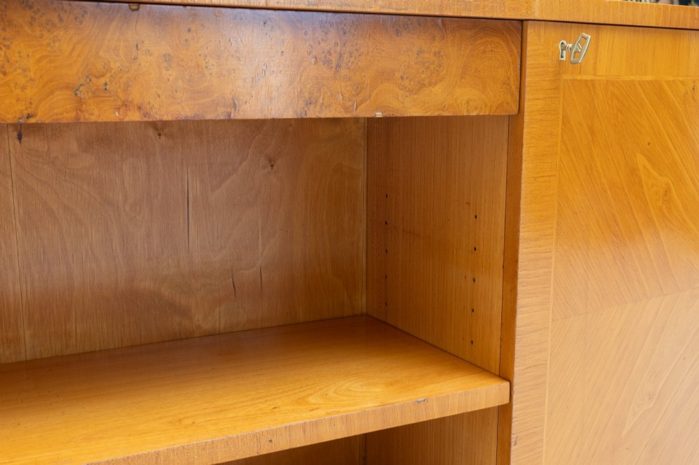 A Swedish Grace birch sideboard featuring chevron parquetry veneer doors, open central shelving, and tapered fluted feet. View VII
