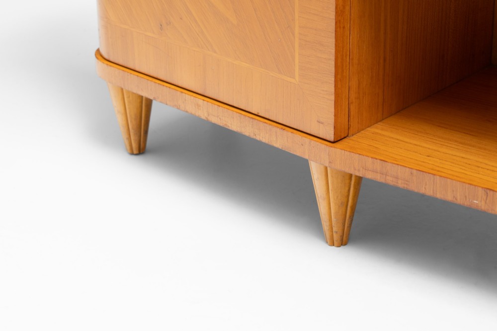 A Swedish Grace birch sideboard featuring chevron parquetry veneer doors, open central shelving, and tapered fluted feet. View IX
