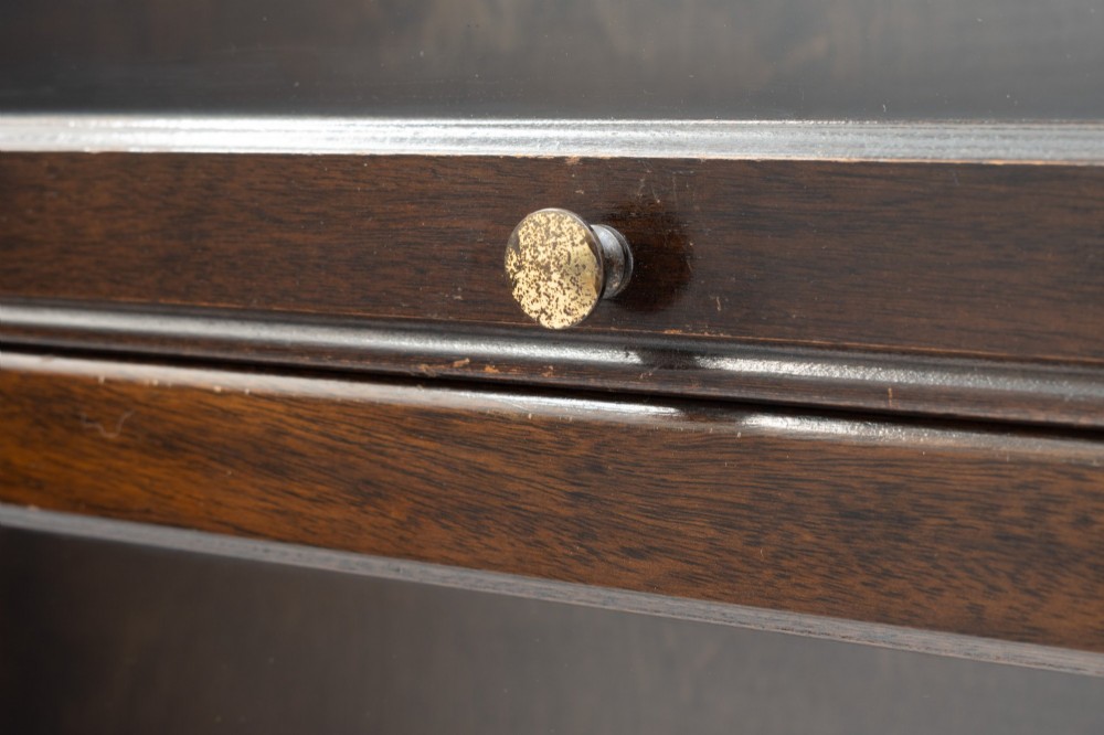 A four-tier dark wood sectional bookcase featuring glazed lift-and-slide doors with central brass knobs. View VIII