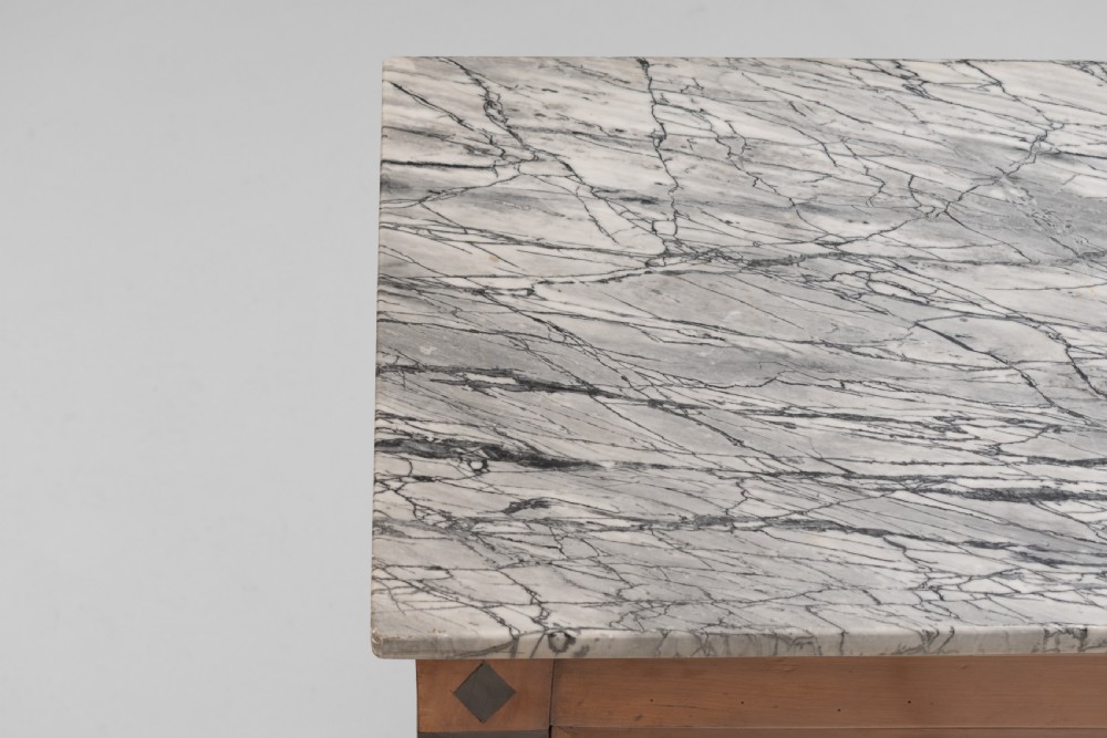 A three-door warm brown wooden sideboard featuring brass trim framing on panelled doors, dark diamond corner inlays, tapered legs, and a grey-veined white marble slab top. View VII