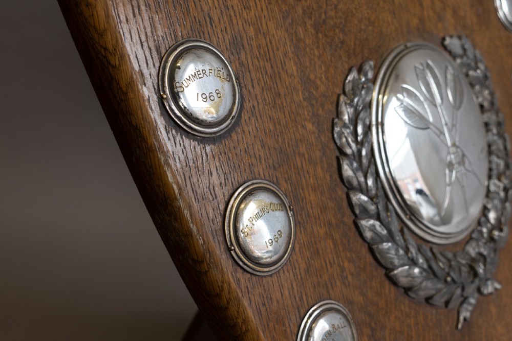 A standing shield-shaped oak presentation trophy featuring an oval silver darts motif surrounded by small silver winner plaques. View VI