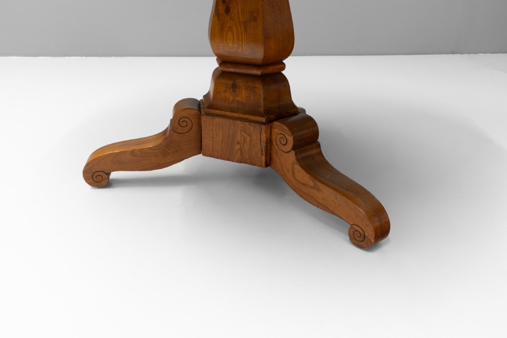 A Victorian tilt-top centre table in golden burr walnut veneer featuring a central starburst inlay and carved tripod pedestal base. View VI