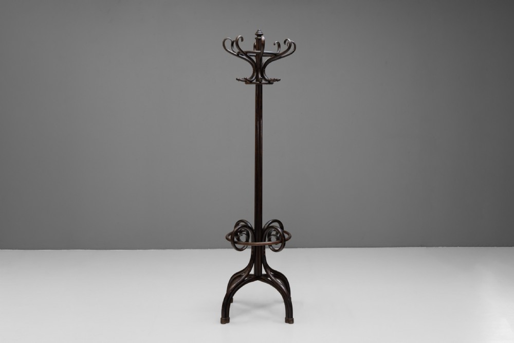 A tall dark brown bentwood coat stand with multiple S-curved hooks at the top, a slender central shaft, an integrated umbrella ring, and four curved splayed legs. View II