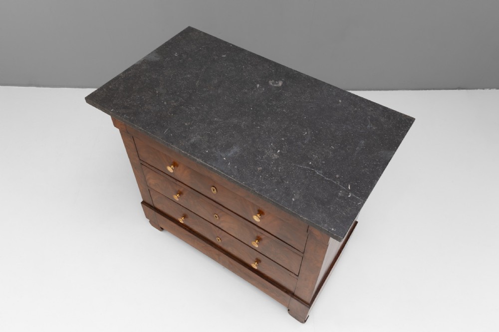 An antique 19th-century French flame walnut commode fitted with a dark grey marble slab top and brass drawer pulls. View VI
