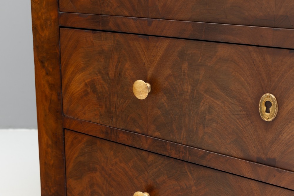 An antique 19th-century French flame walnut commode fitted with a dark grey marble slab top and brass drawer pulls. View VII