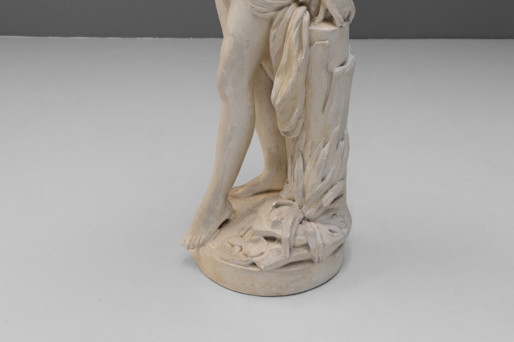 An off-white Neoclassical standing female bather sculpture draped in cloth on a circular base. View VI